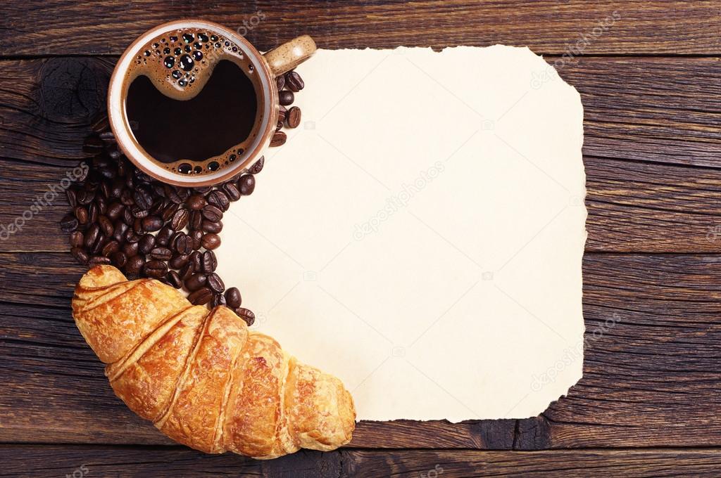 Croissant, coffee cup and old paper