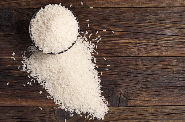 Arroz en un tazón y esparcido cerca —  Fotos de Stock