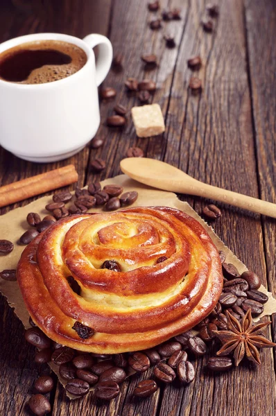 Sweet bun with raisins and coffee — Stock Photo, Image