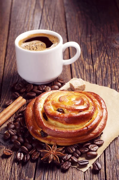 Bun with raisins and coffee — Stock Photo, Image