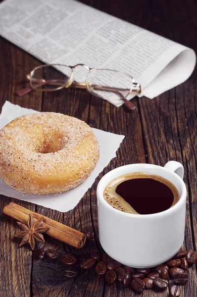 Koffie, donut, krant en glazen — Stockfoto