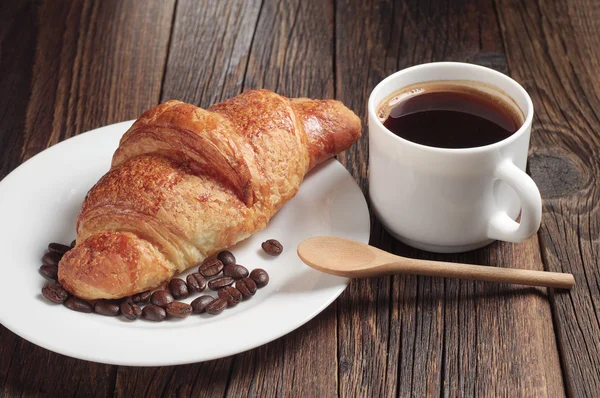 Croissant a kafe pohár — Stock fotografie