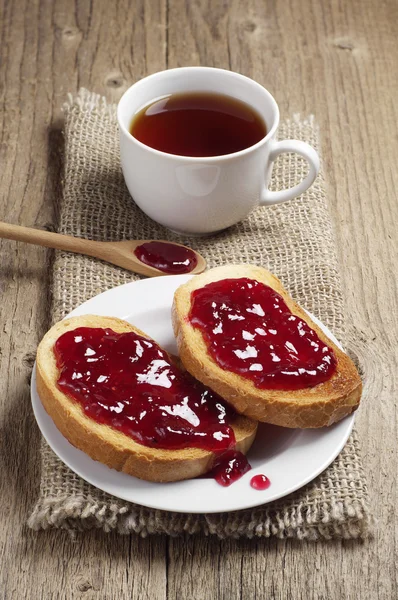 Pan tostado con mermelada de fresa y taza de té — Foto de Stock