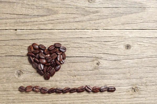 Fundo com grãos de café em forma de corações — Fotografia de Stock