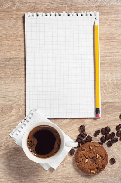 Notizblock und Kaffee mit Plätzchen — Stockfoto