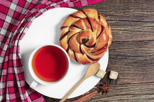 Plate with tea and bun — Stock Photo, Image