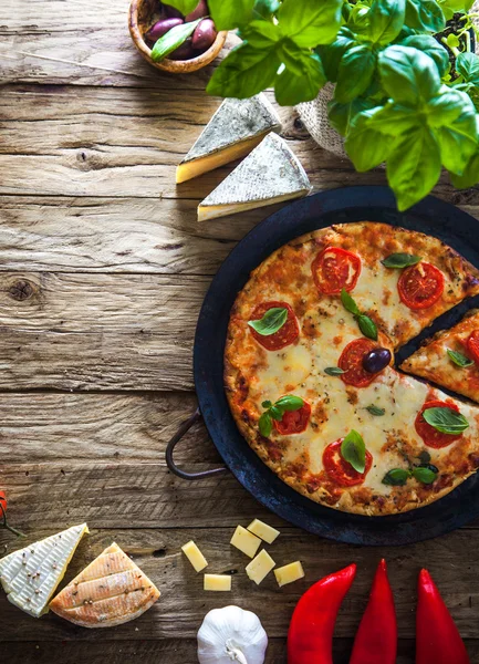 Pizza on wood with ingredients — Stock Photo, Image