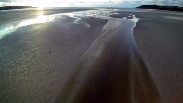 夕暮れ時に海岸に大きなビーチでストリーム上にホバリング 曇りの天気 Uhd空撮 低高度 — ストック動画