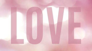 Aşk, Bokeh 'te yanıp sönen ışıkların güzel bir animasyonunda büyük şeffaf bir sözcük. E-kart, kutlama, davetiye ya da başlık için pürüzsüz bir döngüde yumuşak pembe ve açık sarı bir sıra...