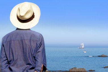 Sahilde bir şapka ile gemi ayakta bakarak kadın ve 