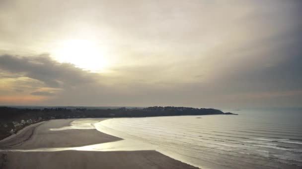 Time-lapse scenery of a bay in evening during the tide. The light is golden and the sea has silver reflections. Waves and clouds are moving fast. Full HD, 1920x1080. — Stock Video