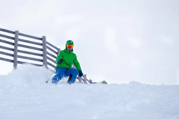 Skifahrer kommt den Hang hinunter Stockfoto