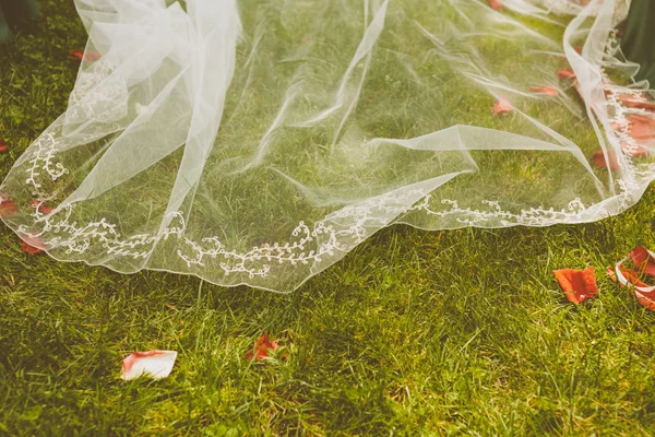 Detalle de un vestido de novia sobre un piso de hierba —  Fotos de Stock