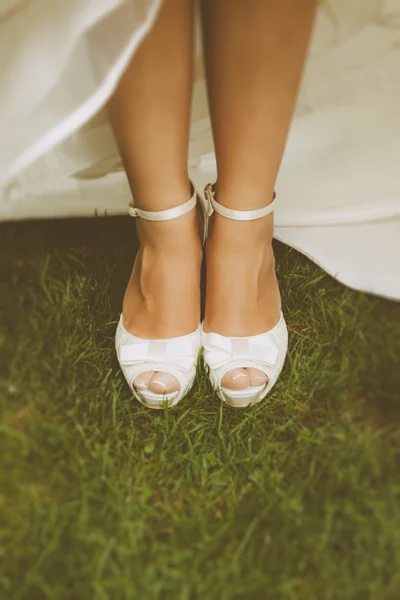 Bride 's White Shoes on a Grass Field — стоковое фото