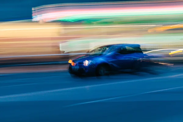 Carro esporte azul em uma cidade turva — Fotografia de Stock