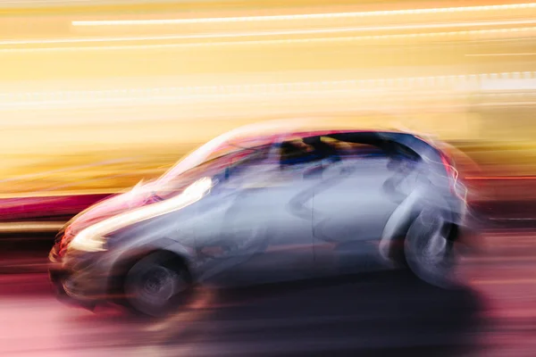 Grey Compact Car in a Blurred City — Stock Photo, Image