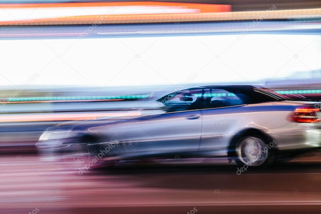 Grey Luxury Car in a Blurred City