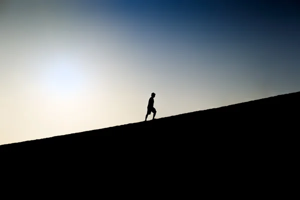 언덕을 등반 한 남자의 실루엣 — 스톡 사진