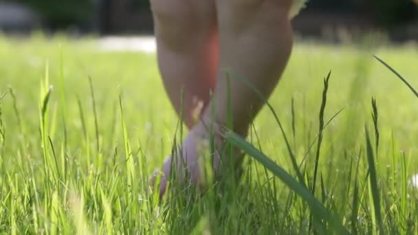 Small babys cute feet on the grass — Stock Video