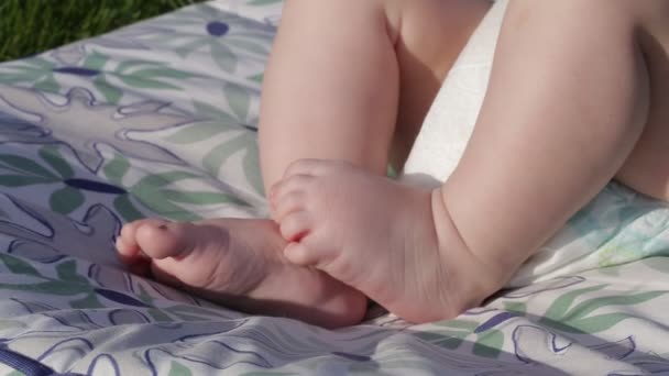 Kleine babys süße füße auf dem gras — Stockvideo
