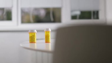 Adam bir kutu hap masanın üzerine alır