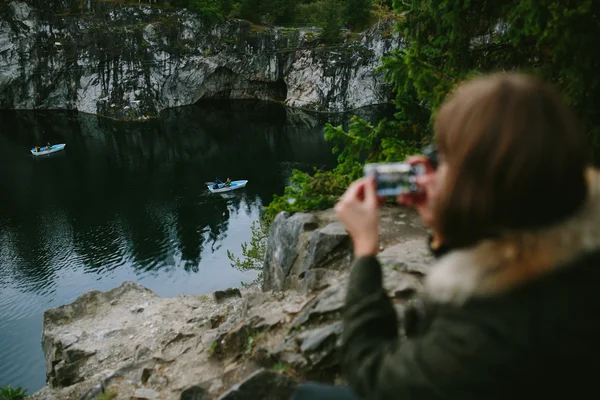 Mädchen fotografierte auf einem Felsen stehende Boote Stockfoto