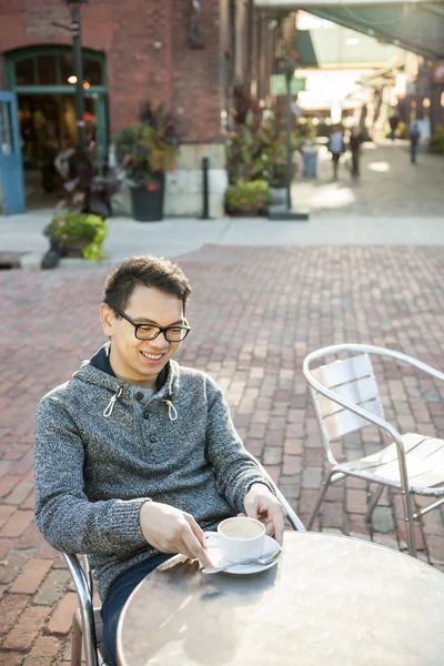 Молодий азіатський чоловік у відкритому кафе — стокове фото