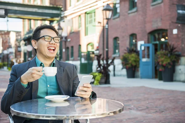 Riéndose asiático hombre en al aire libre café — Foto de Stock