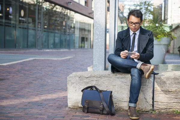 Молодий азіатський чоловік дивиться на мобільний телефон — стокове фото