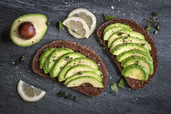 Avocado auf dunklem Roggenbrot — Stockfoto