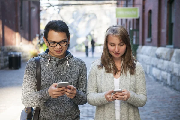 Two young people with smart phones — Stock Photo, Image