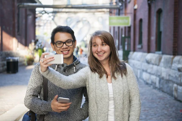 Dva mladí lidé s selfie s smartphone — Stock fotografie