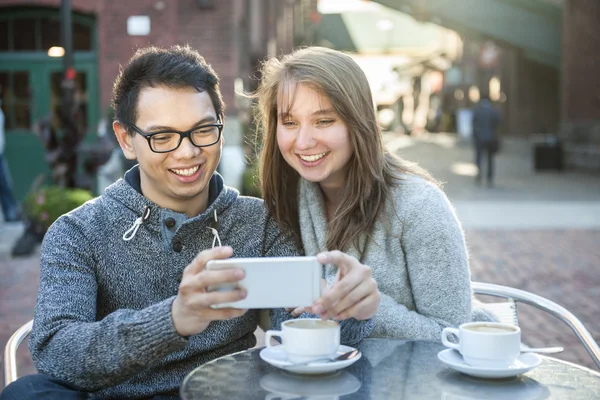 İki genç insan ile smartphone Cafe — Stok fotoğraf