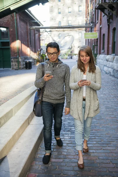 Δύο νέοι άνθρωποι με έξυπνα τηλέφωνα — Φωτογραφία Αρχείου
