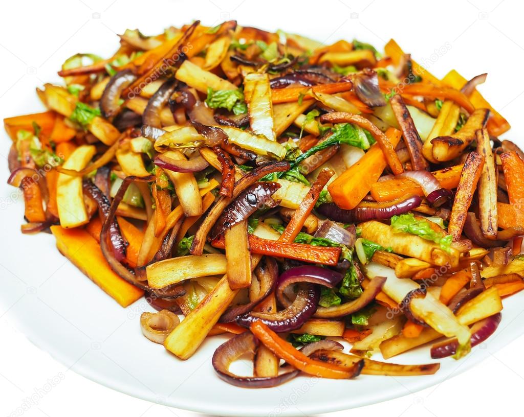 Fried root vegetables on a white plate towards white