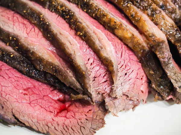 Smażone soczysty doświadczonych czerwone mięso na białym talerzu — Zdjęcie stockowe
