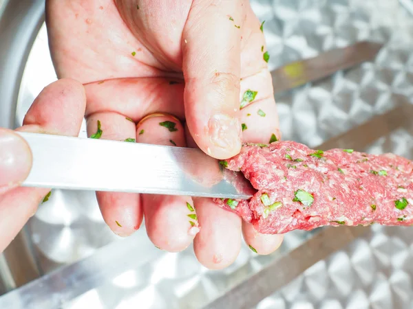 Un chef haciendo shish kebab de carne roja con perejil sobre metal pl — Foto de Stock