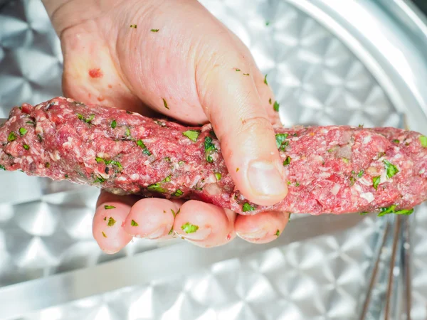 Kuchař dělat ražniči červeného masa s petrželkou za kovové pl — Stock fotografie