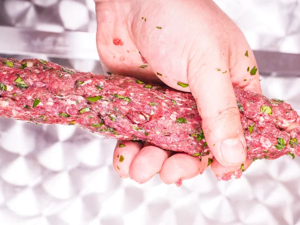 Un chef haciendo shish kebab de carne roja con perejil sobre metal pl — Foto de Stock