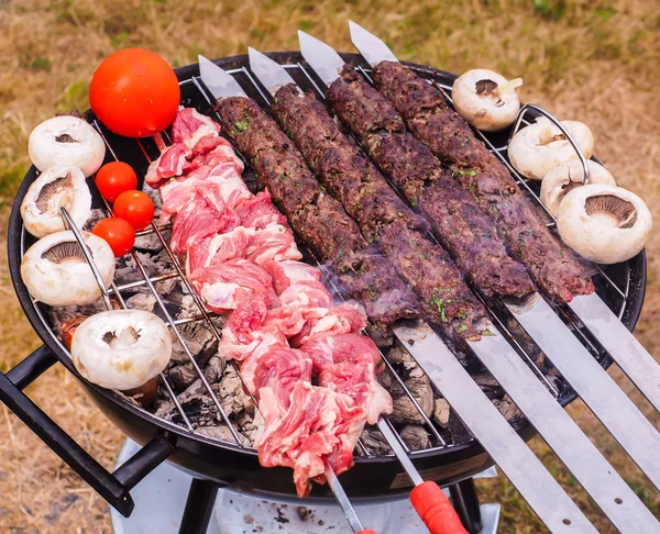 Shish kebab tillagas över en svart rund formad träkol grill — Stockfoto