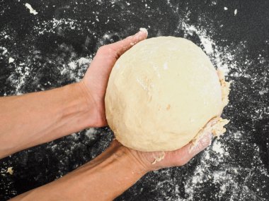 Kanıtlanmış bir hamur un karışıklık ile siyah tablo üzerinde tutan kişi