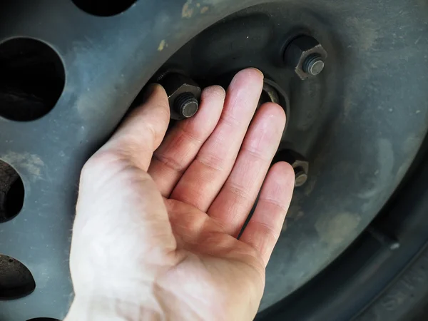 Person checking nuts and bolts on a vehicle — Stock Photo, Image