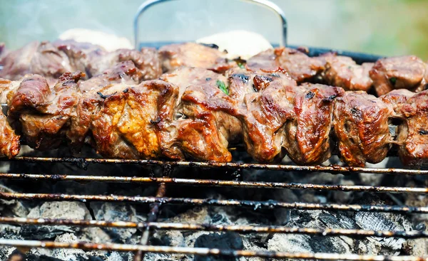 Carne de vaca suculenta em espetos sobre churrasco — Fotografia de Stock