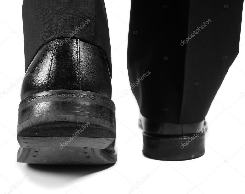 Male suit walking away in black worn shoes