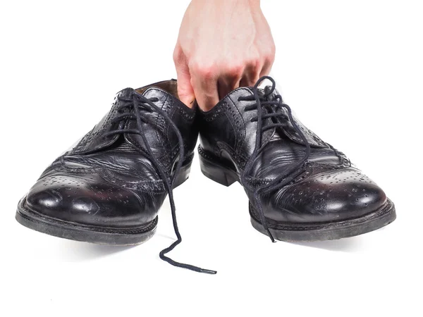 着用の黒革の靴のペアを保持している男性の手 — ストック写真