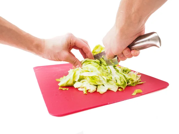 Hands cutting fresh green lettuce salad with grey metal knife on — Stock Photo, Image