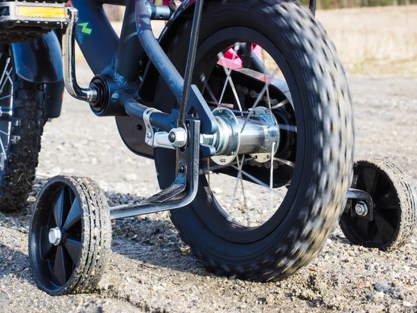 Bicycle with supporting wheels stuck in loose gravel — Stock Photo, Image