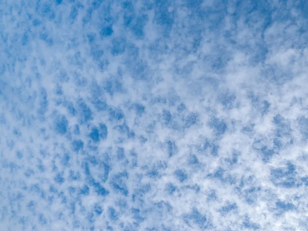 Massor av molnet prickar på en klart blå himmel — Stockfoto
