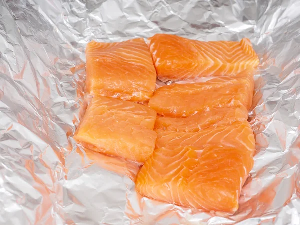 Close-up van ongezouten zalm stukken in aluminiumfolie — Stockfoto