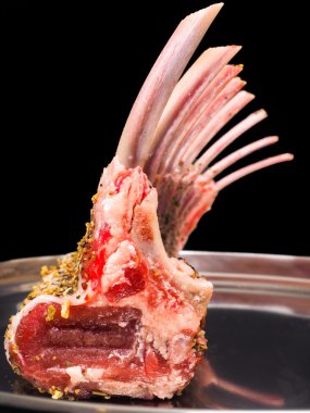Rack of lamb seasoned on a silver plate